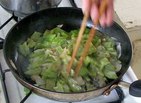 stiring nopal cactus in a skillet