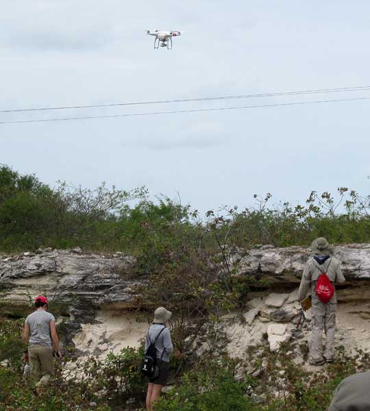 GEOLOGY STUDENTS IN A BARROW PIT, WATCHED BY A DRONE
